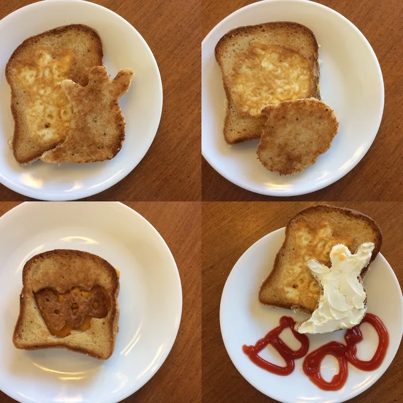 first halloween sandwich has ghost cut out in the centre and filled with egg, second halloween sandwich has pumpkin cut out in centre and filled with egg, third halloween sandwich has the letter BOO cut out in centre, fourth halloween sandwich has a ghost cut out in centre and filled with egg