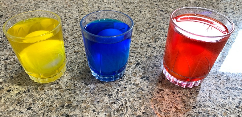 eggs in cups with food colouring dye