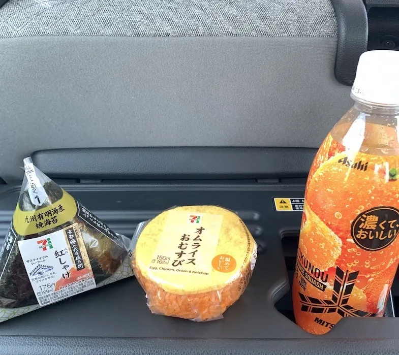 Seven Eleven salmon and omurice onigiri with a drink on the car table