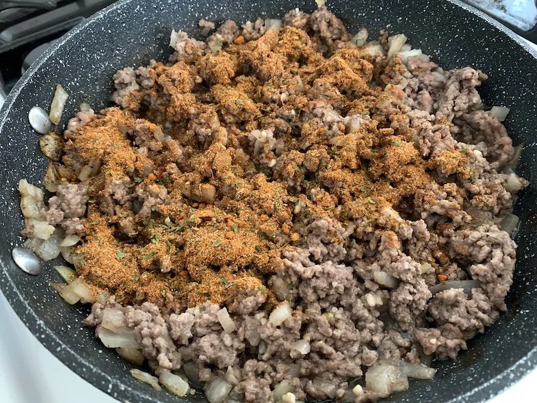 gluten-free taco seasoning added to meat in frying pan