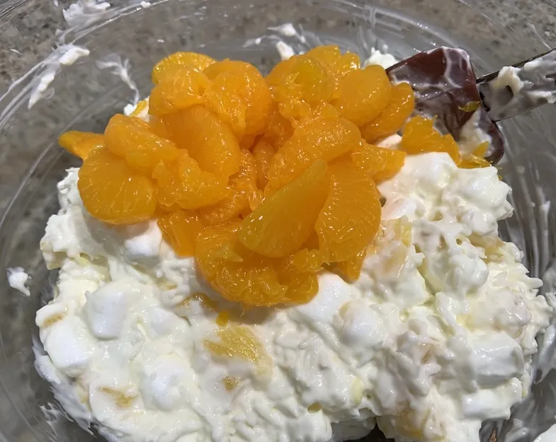 adding mandarin oranges to the Ambrosia Salad