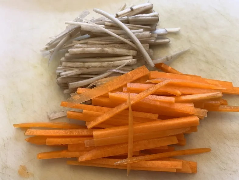 burdock and carrot julienned on a cutting board