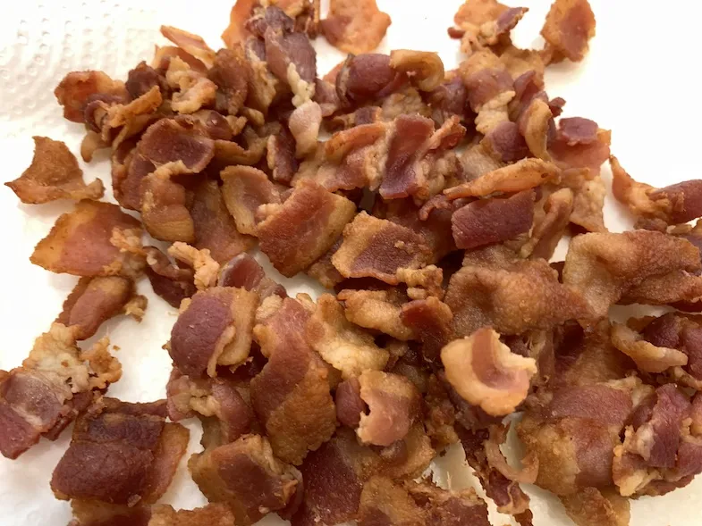 Fried cut up bacon on a plate