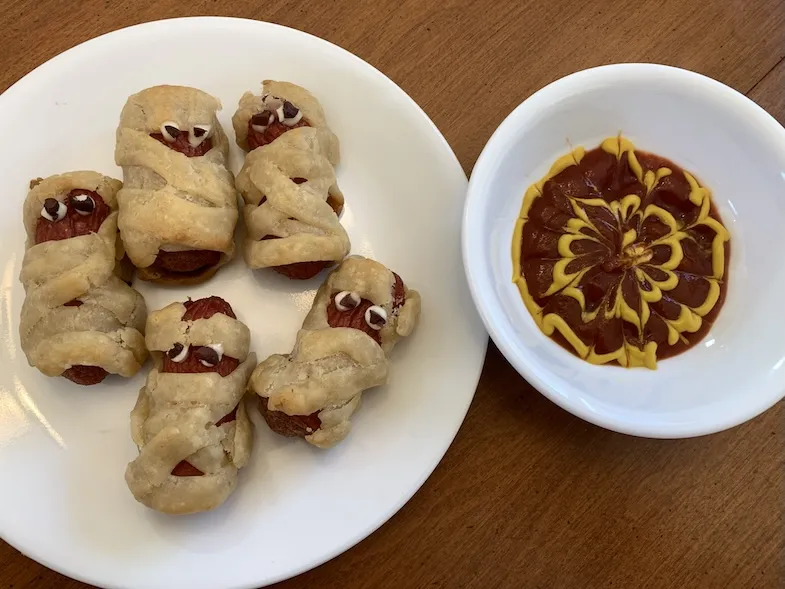 gluten-free Halloween mummy hot dogs on a plate with dip