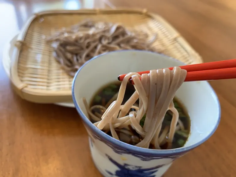 gluten-free soba noodles being dipped in gluten-free tsuyu