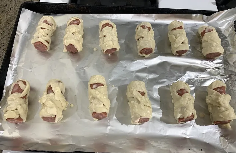 gluten-free wrapped mummy hot dogs on baking tray