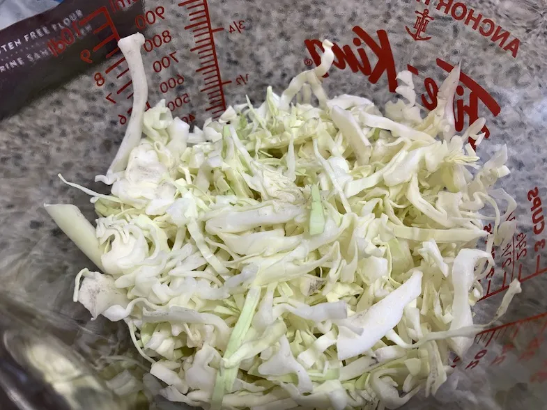 Finely chopped cabbage in a measuring cup