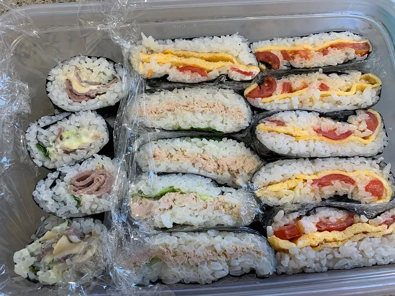 a variety of gluten-free onigirazu in a picnic box