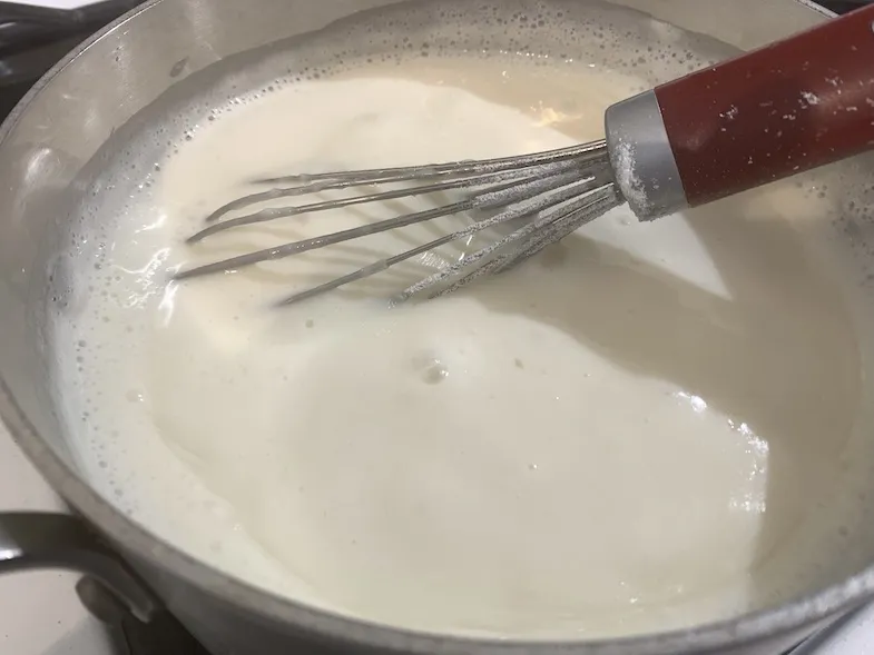 custard in the pot with a whisk